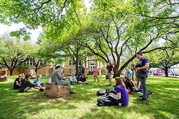 A professor teaching students in an outdoor space